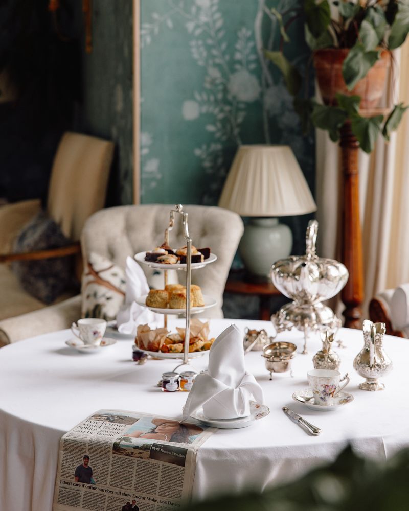 Afternoon tea laid out in a sitting room at Birkhill Castle, silver tea service and a three-tier stand