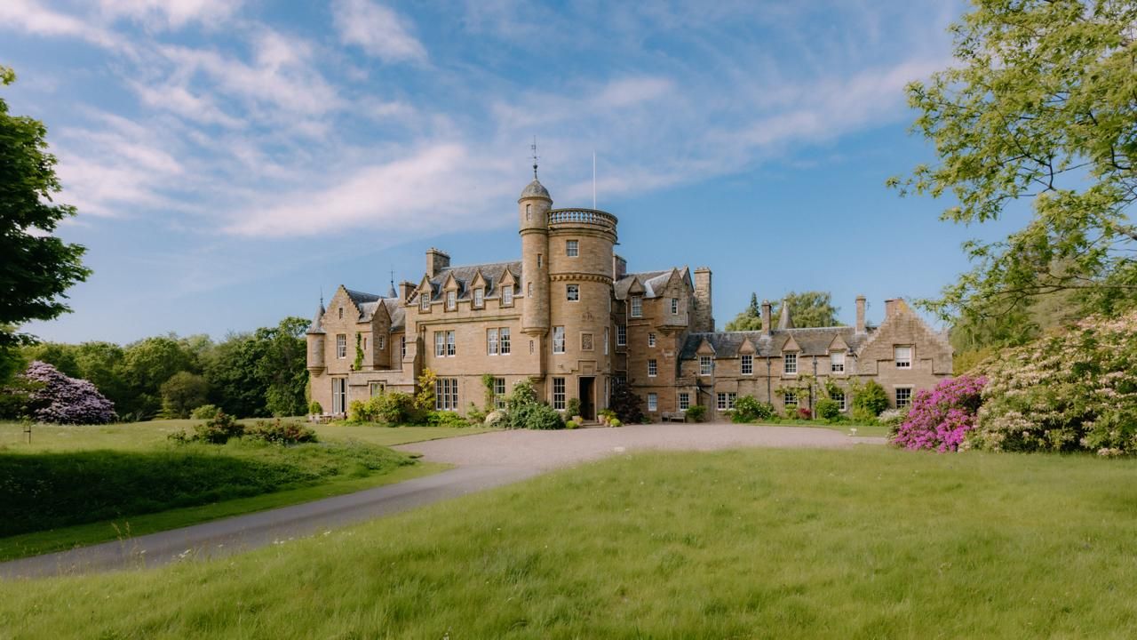 Birkhill Castle under a clear blue sky, seen across the front lawn