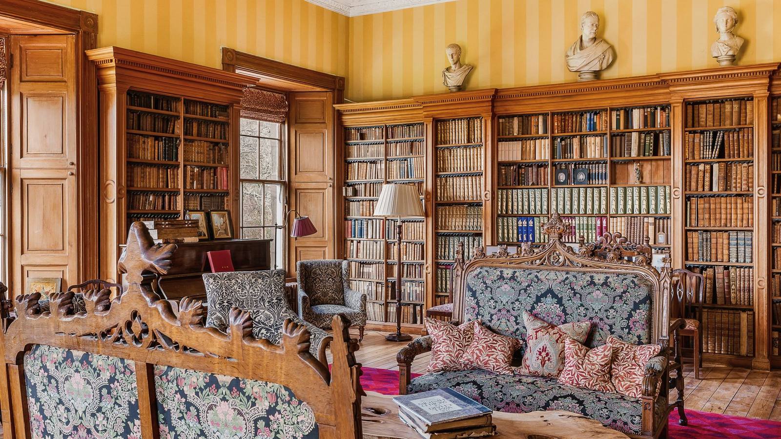 The drawing room at Birkhill Castle, yellow striped walls, marble busts, and William Morris upholstered furniture