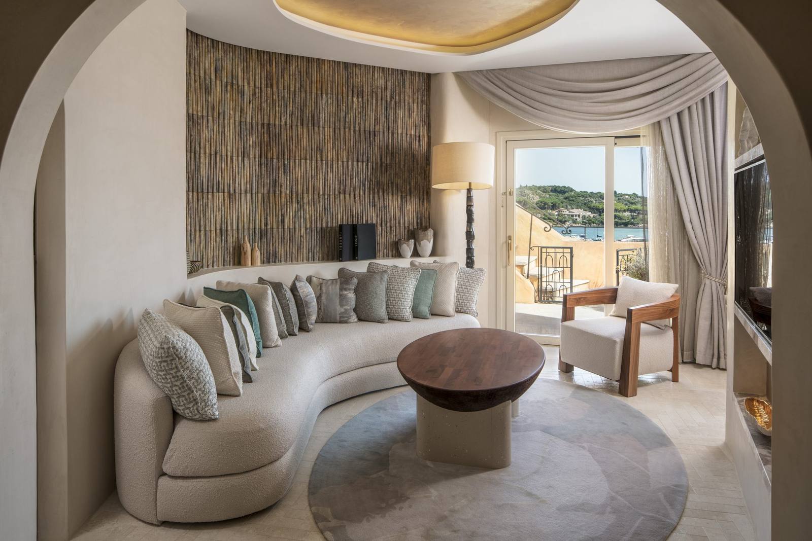 The living room of the Harrods Suite, with curved seating and soft neutral tones