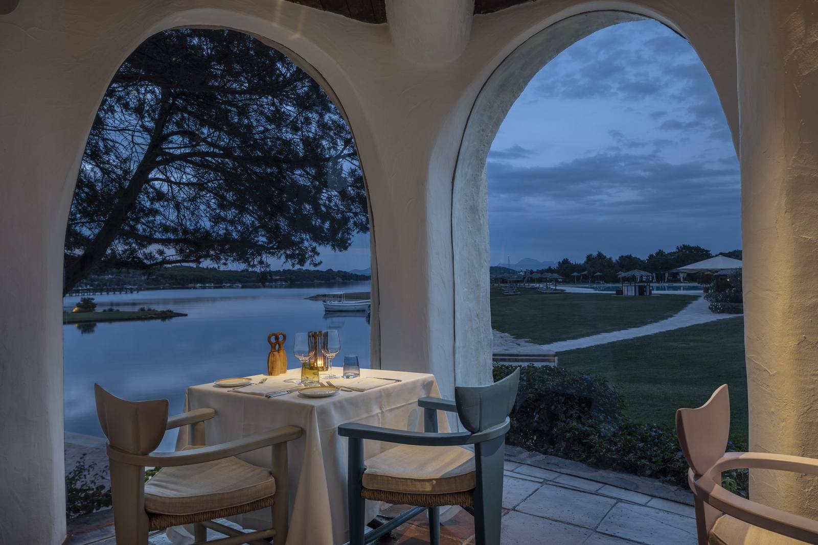 A table for two beneath an arch at Le Grand, looking out over the bay at dusk