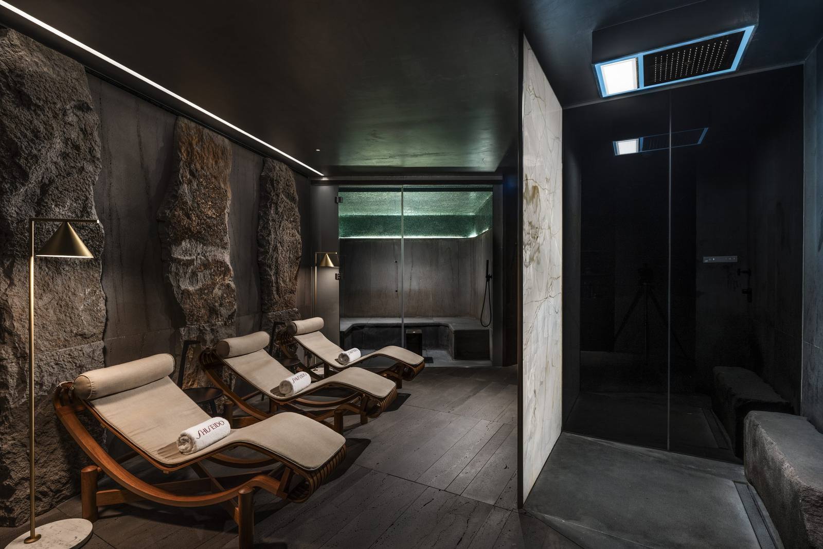 The relaxation room of the Shiseido Spa at Cala di Volpe, with loungers and dark stone walls