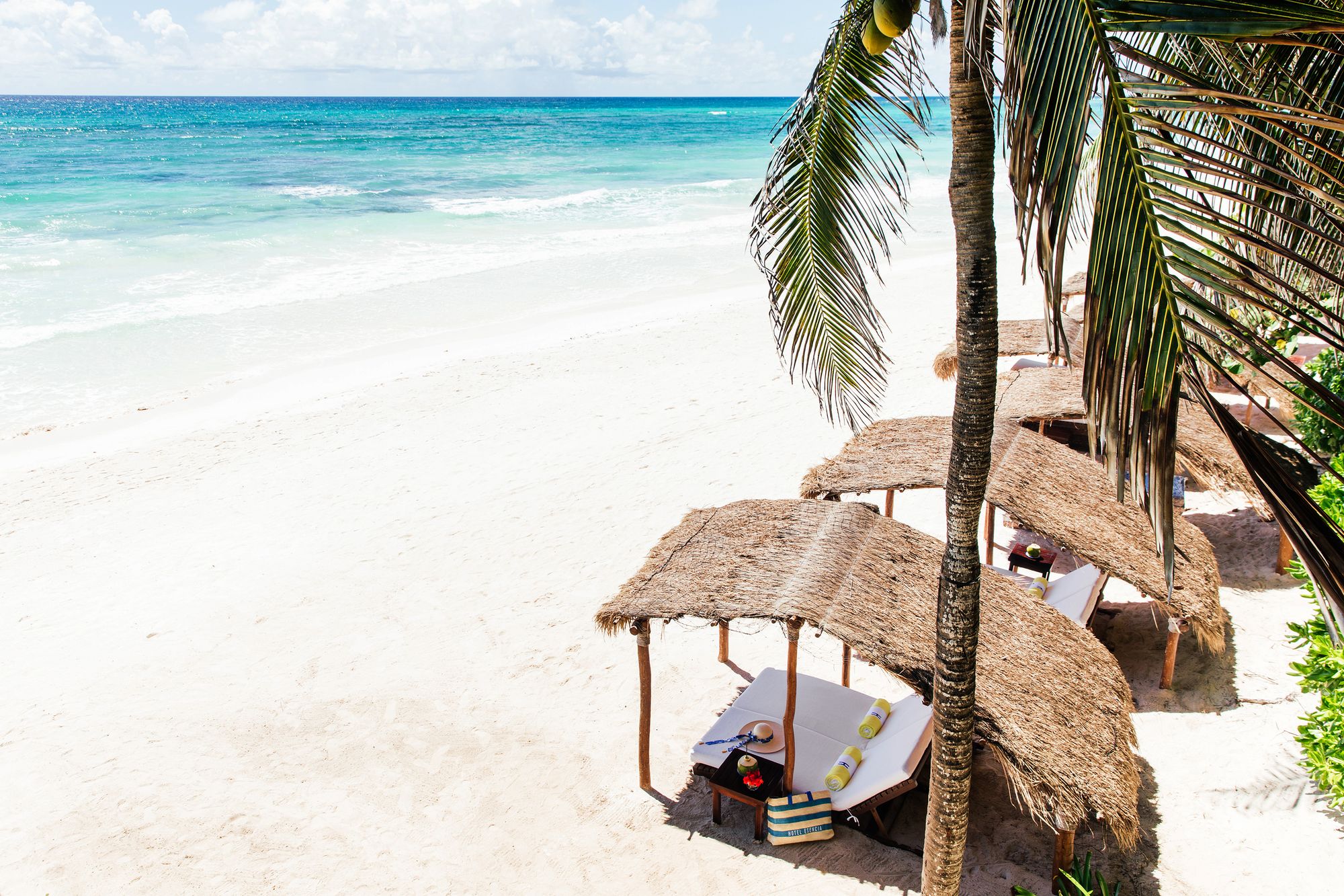 Palapa sunbeds on the white sand of Xpu-Ha beach
