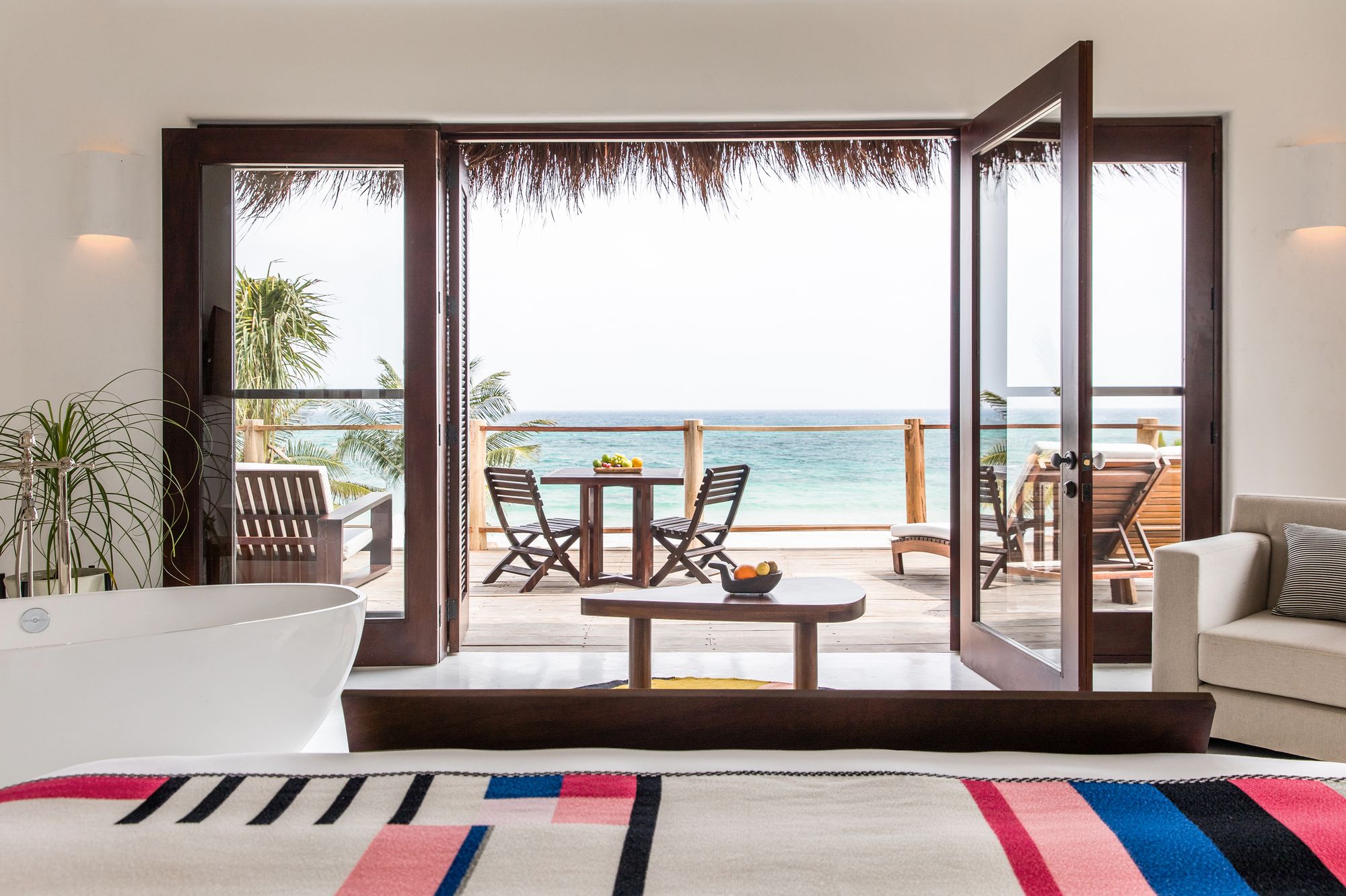 Master Beach Suite at Hotel Esencia with doors open to a terrace and the sea