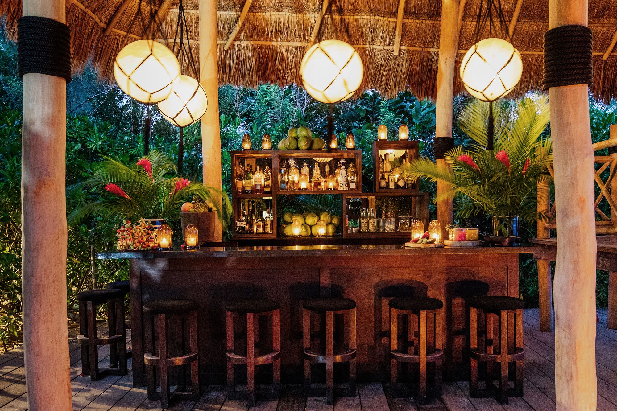 The lantern-lit beach bar under a palapa at Hotel Esencia