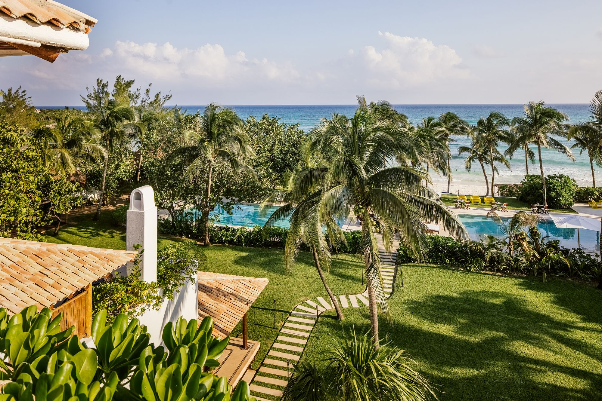 Gardens and palms of Hotel Esencia leading down to the Caribbean