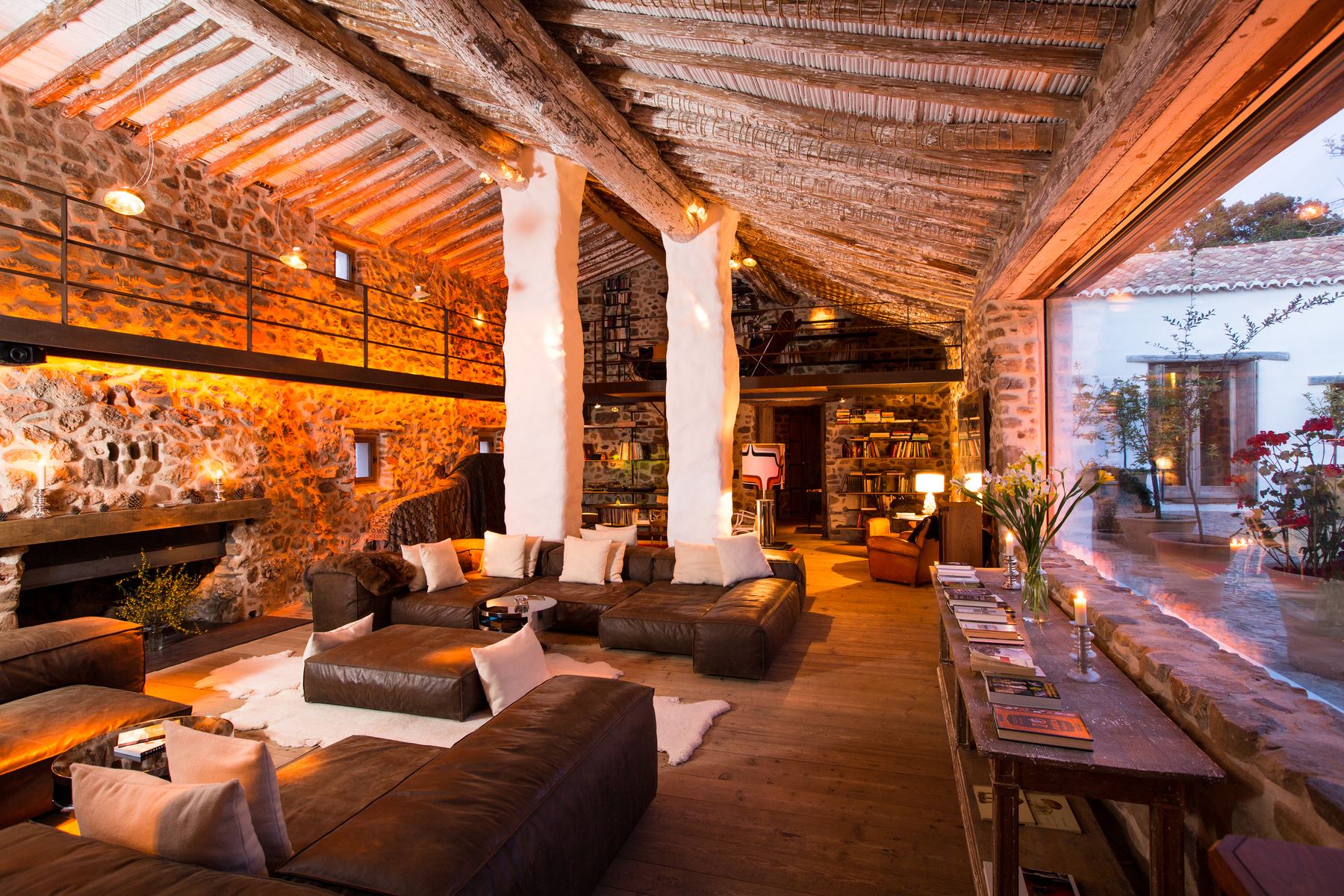 The cortijo's main living room: whitewashed pillars, timber ceilings and low leather sofas lit warmly
