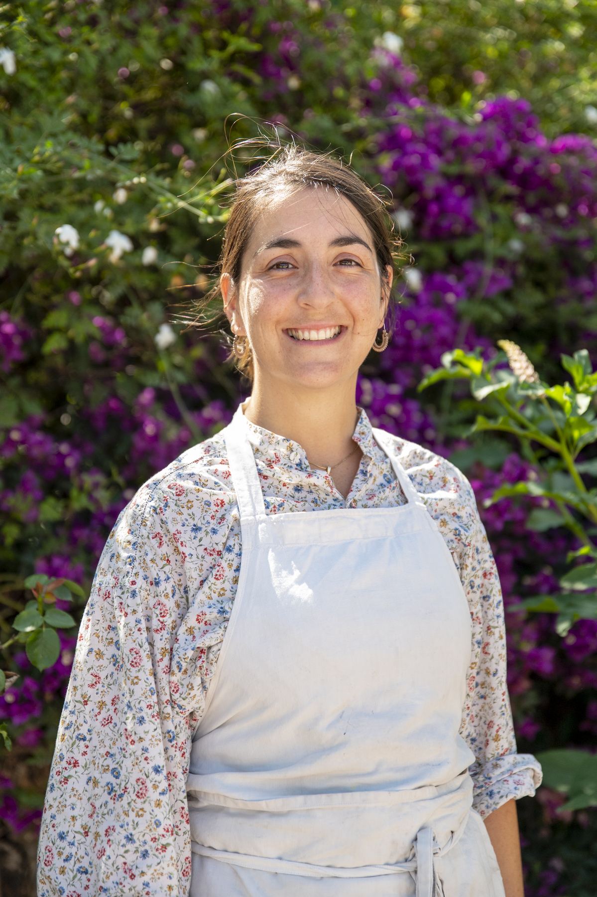 Chef Nerea Ortiz de Urbina in an apron in front of bougainvillea