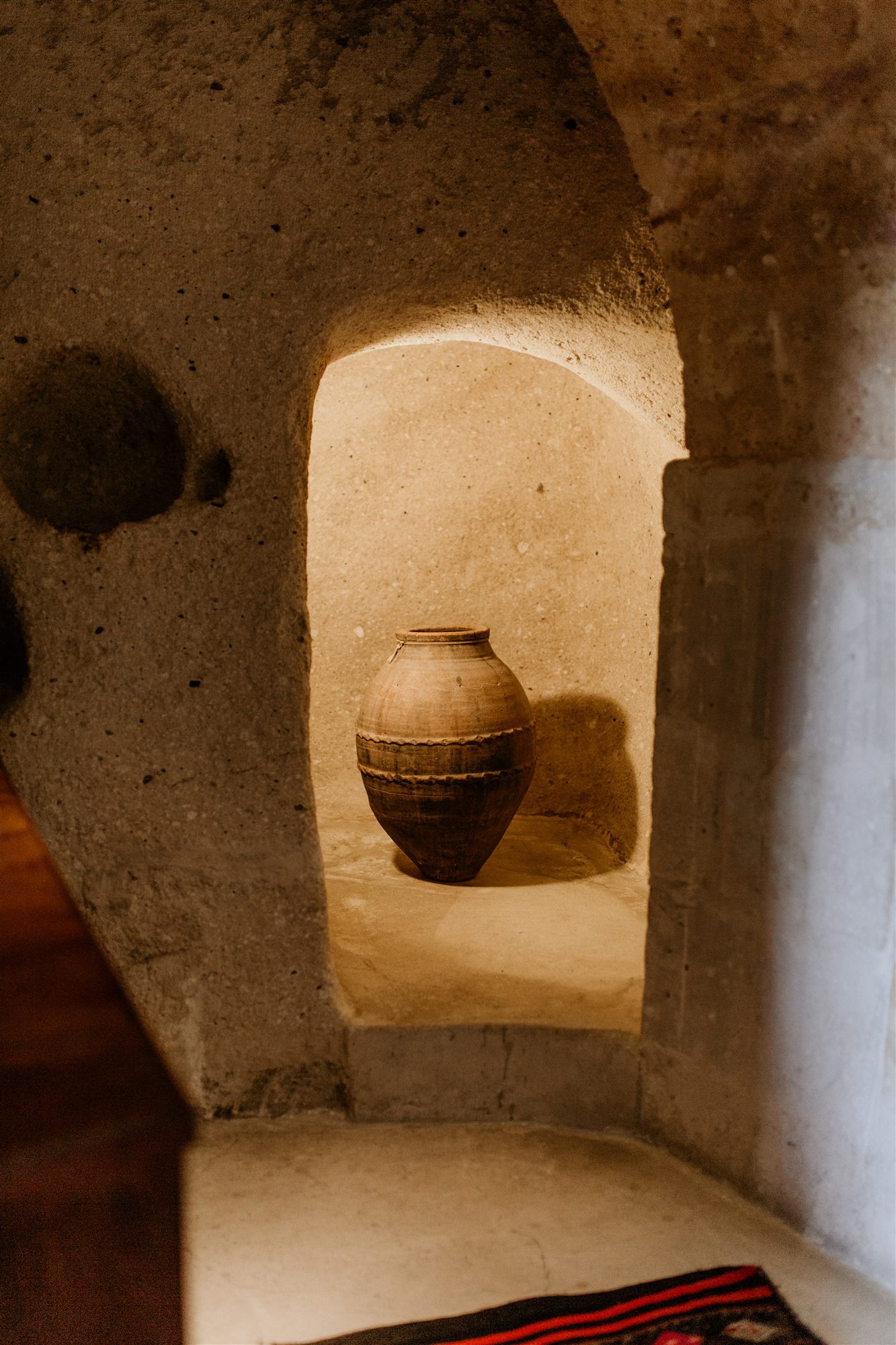 Antique clay amphora displayed in a carved cave niche at Museum Hotel, Uçhisar