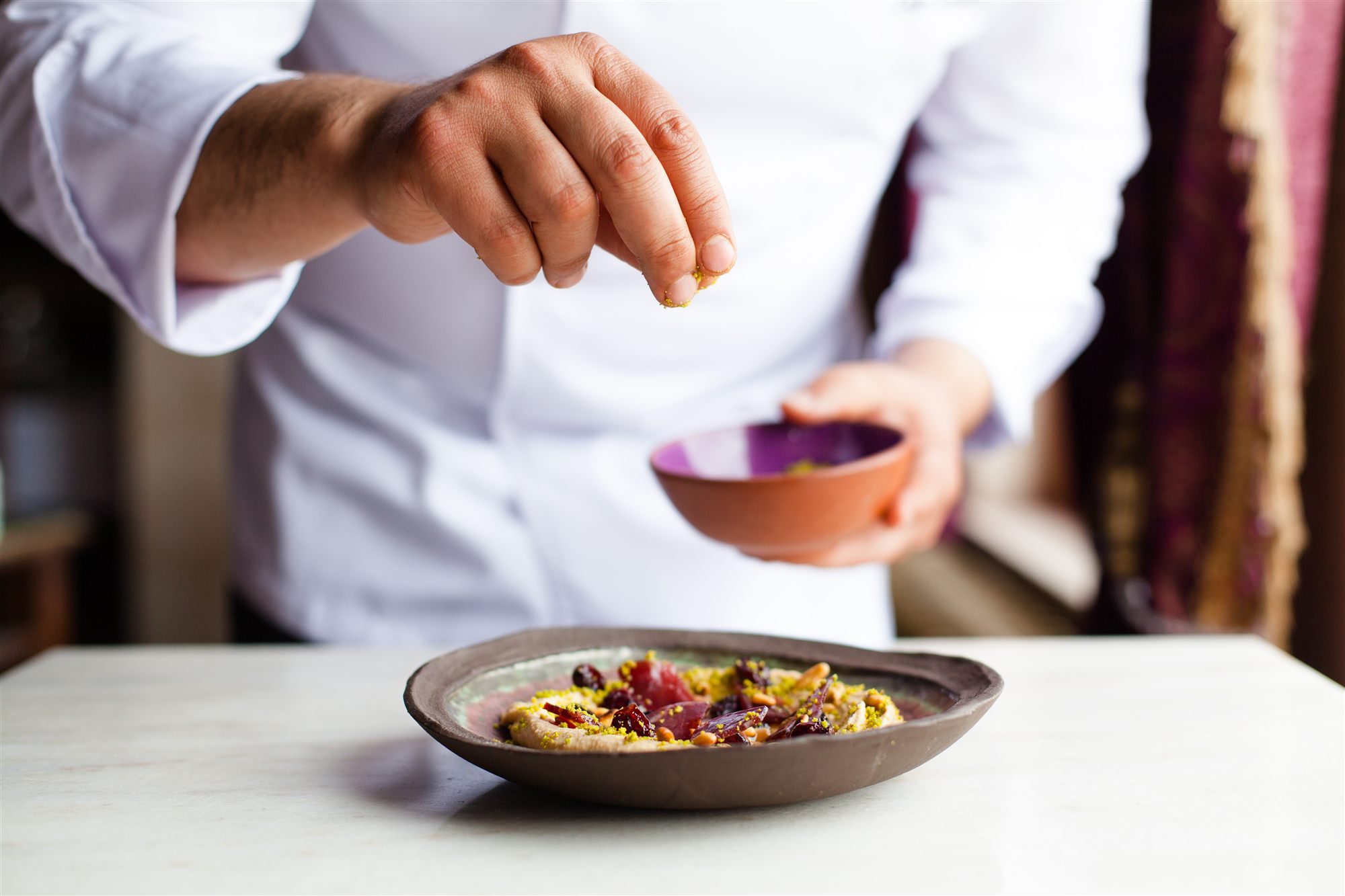 Chef finishing a plate at Lil'a Restaurant, Museum Hotel, Cappadocia