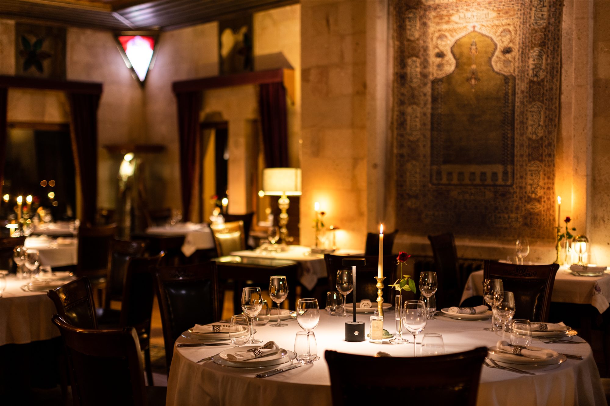 Lil'a Restaurant at Museum Hotel, Cappadocia, with candlelit tables, stone walls and antique tapestries
