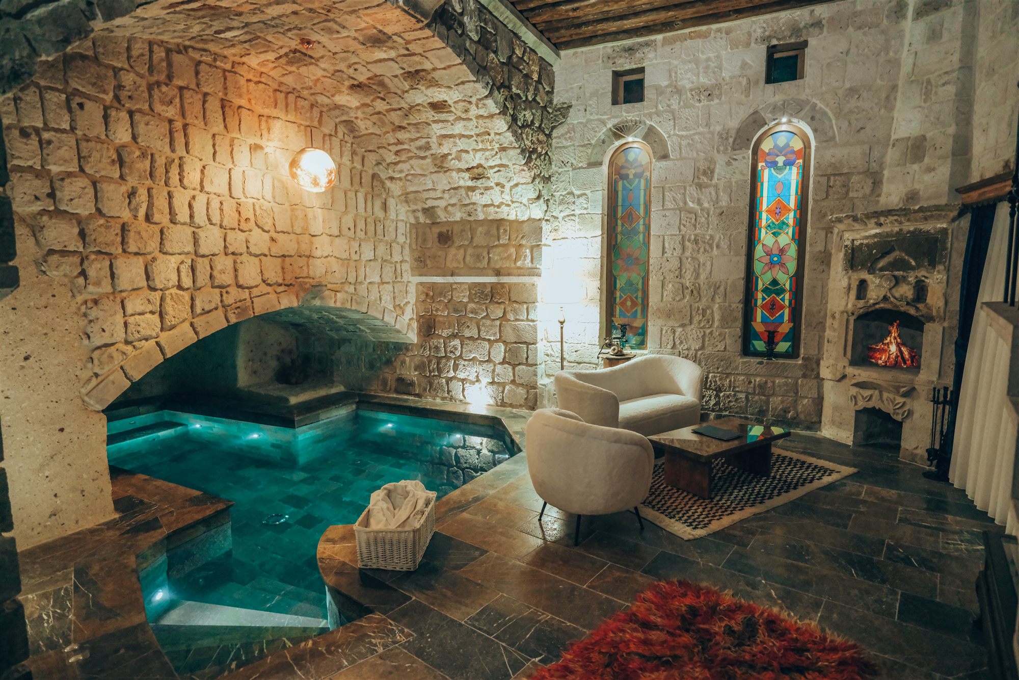 Suite at Museum Hotel with a private indoor pool beneath stone arches, stained glass windows and a fireplace
