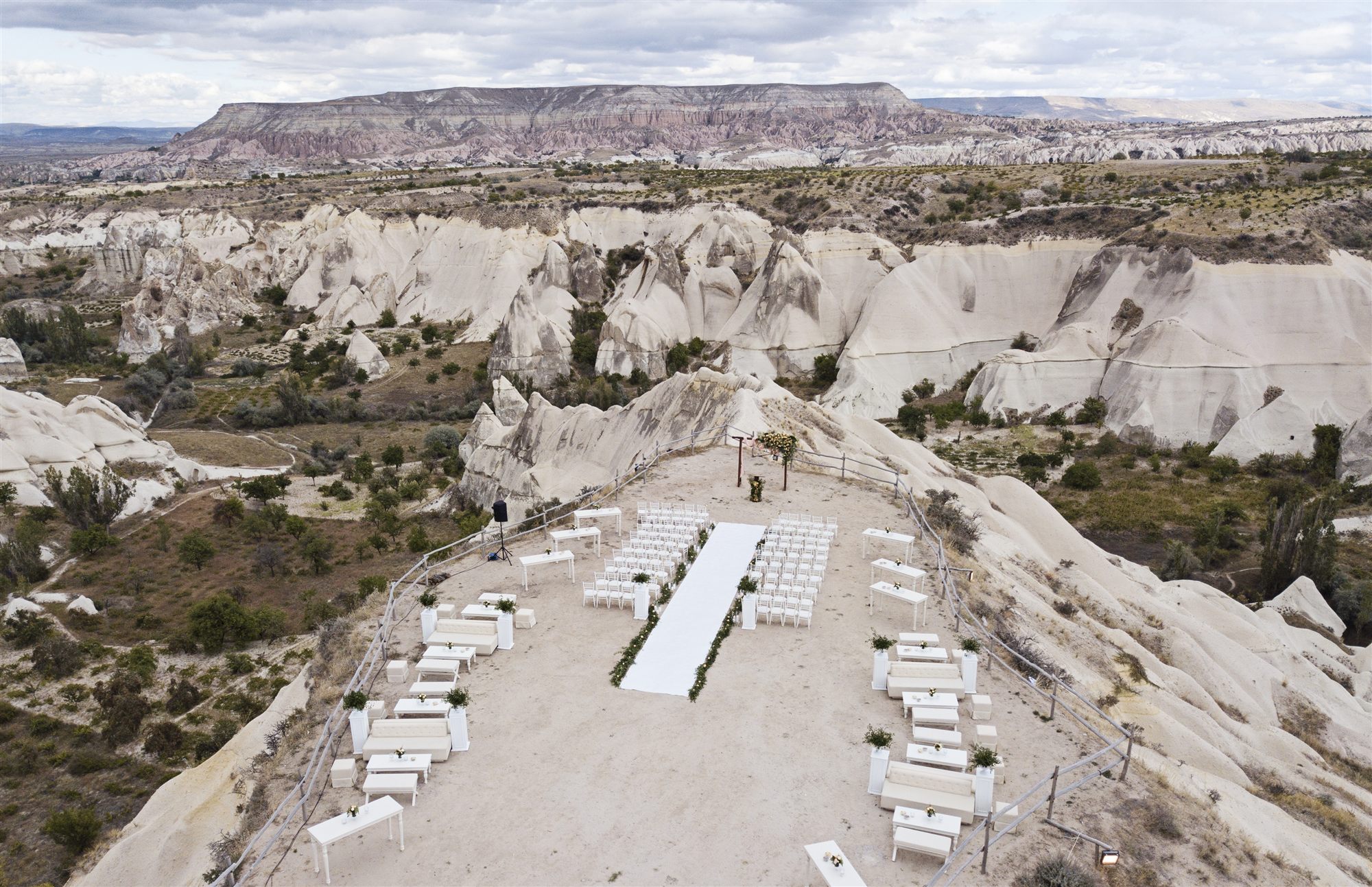 Outdoor wedding ceremony set on a rock ridge above the valleys of Cappadocia, arranged by Museum Hotel