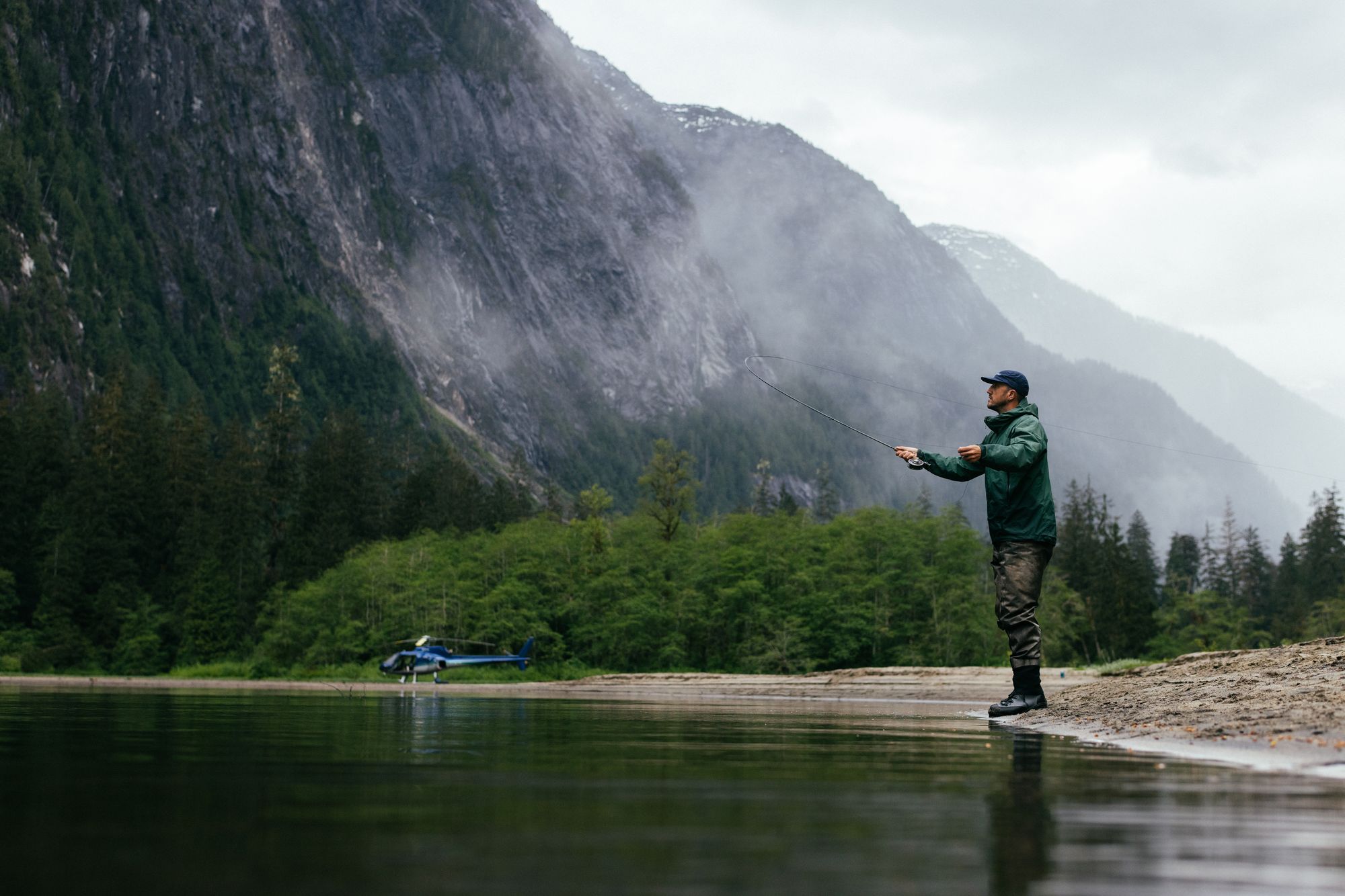 Guest fly fishing on a remote river reached by helicopter from Nimmo Bay