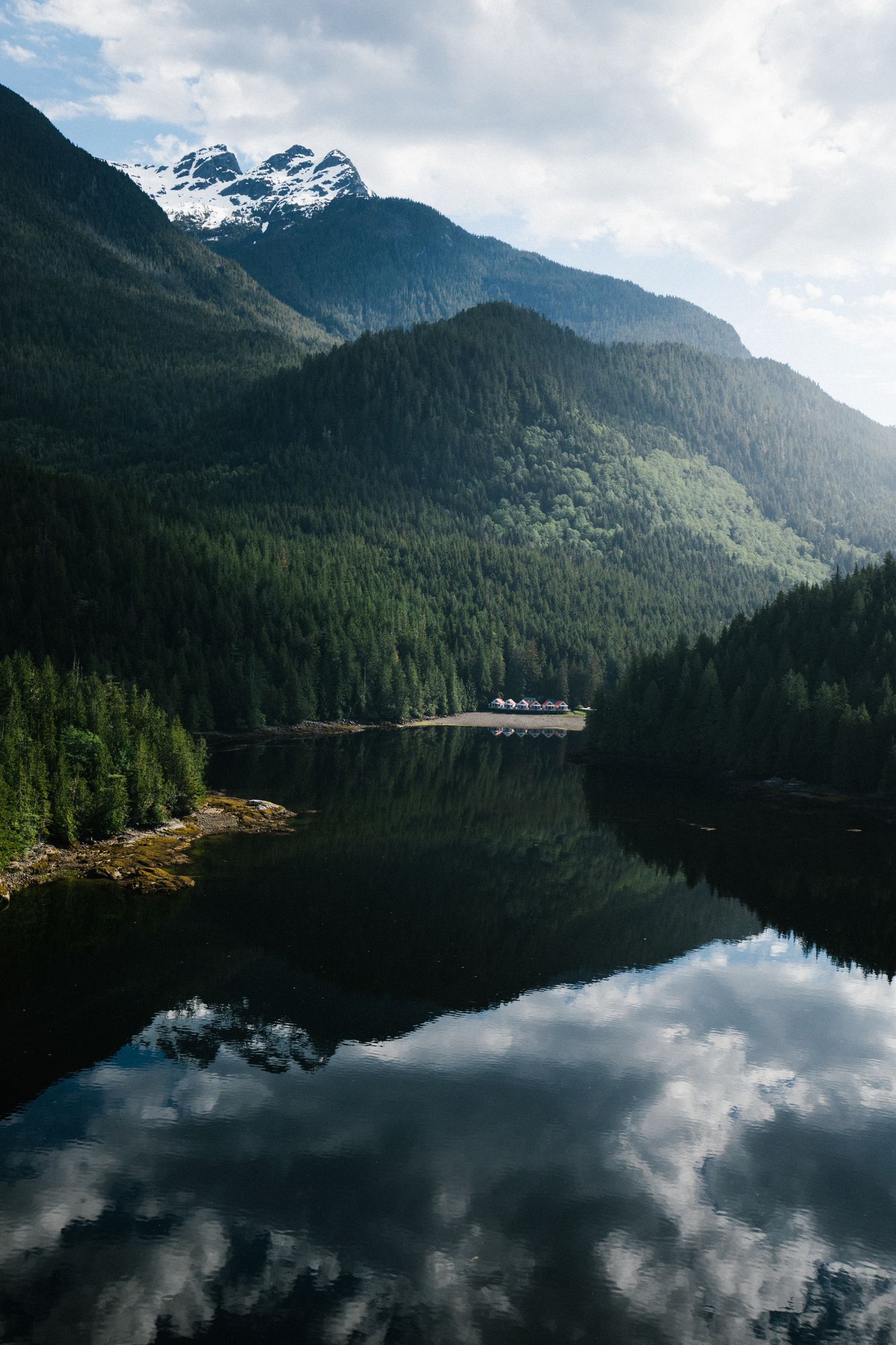 Mountains and forest mirrored perfectly in the still waters near Nimmo Bay