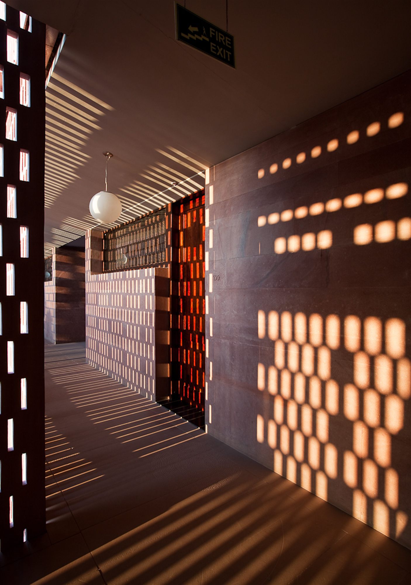 Evening light glowing through a sandstone jaali screen in a corridor at RAAS Jodhpur