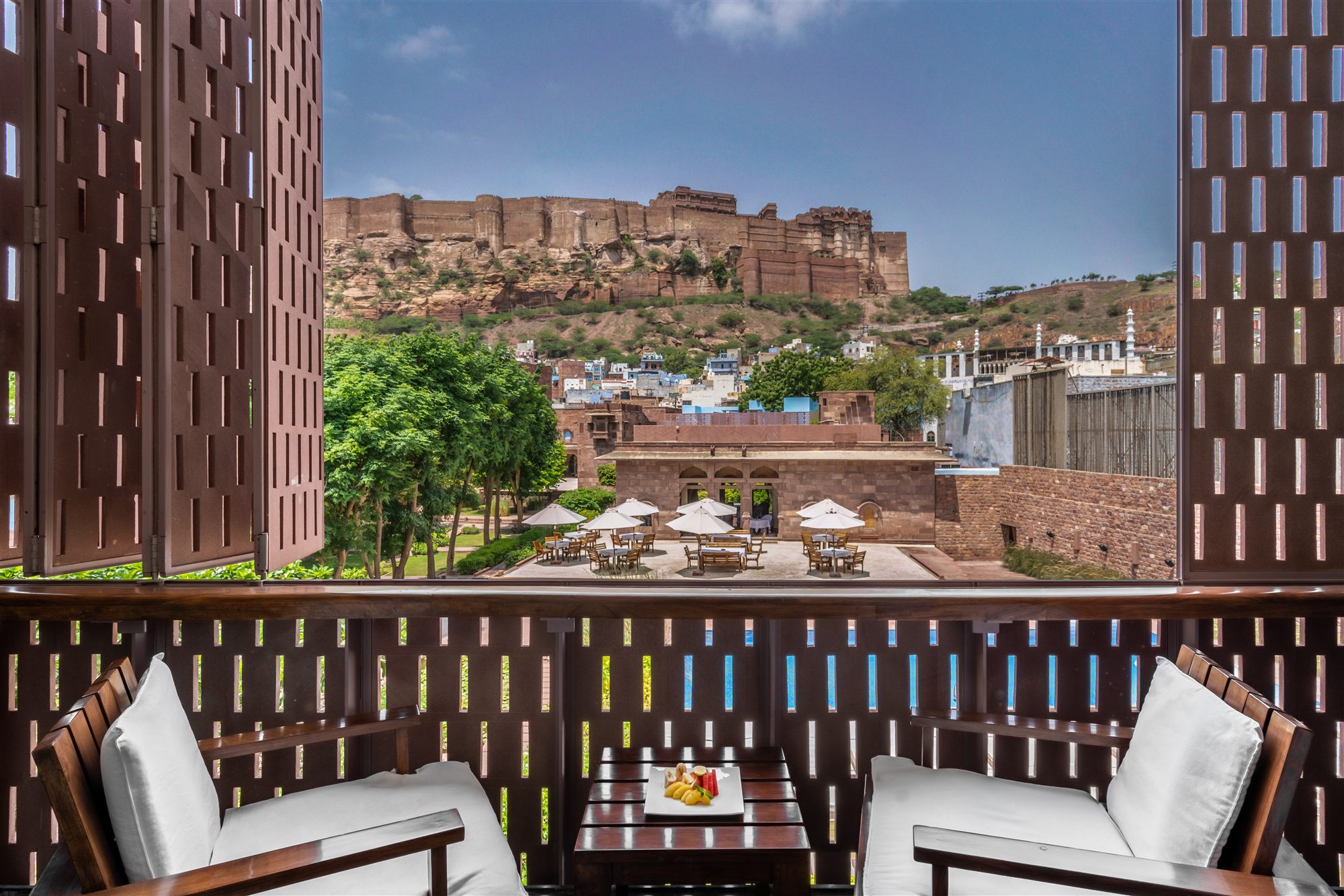 Private balcony with two armchairs and a sandstone lattice screen opening onto Mehrangarh Fort at RAAS Jodhpur