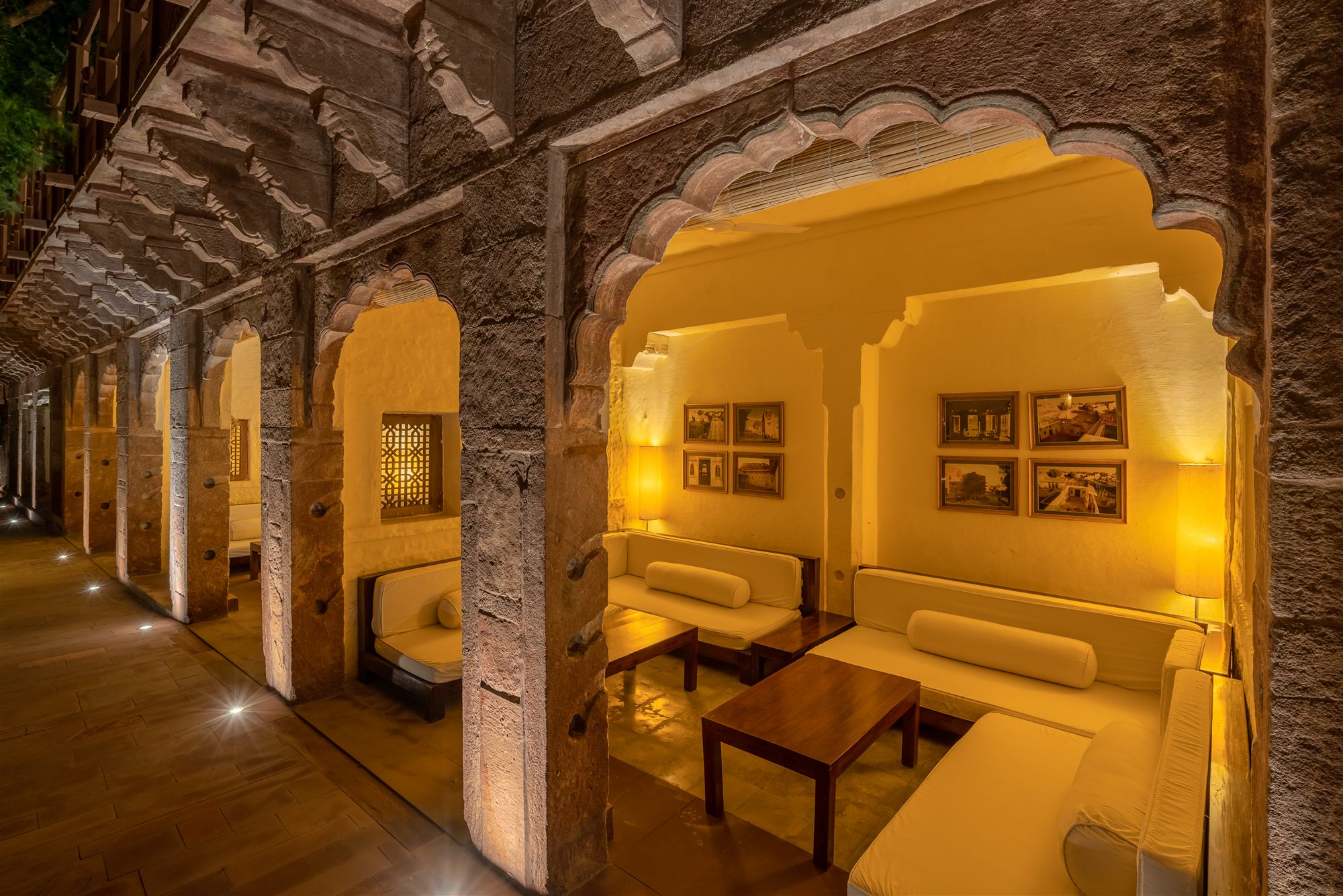 Scalloped sandstone arches and a lamp-lit seating alcove in the heritage haveli at RAAS Jodhpur
