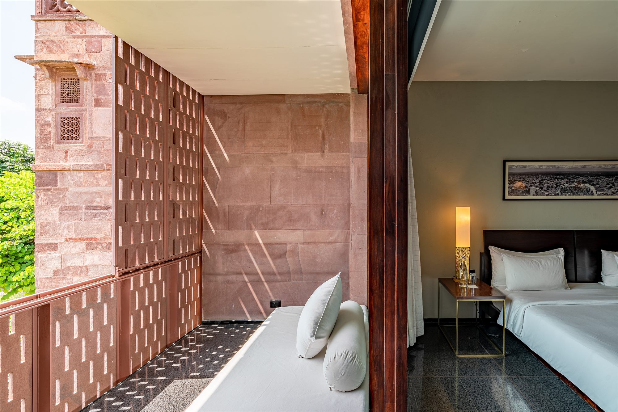 Private sit-out with a white daybed behind sandstone lattice screens at RAAS Jodhpur