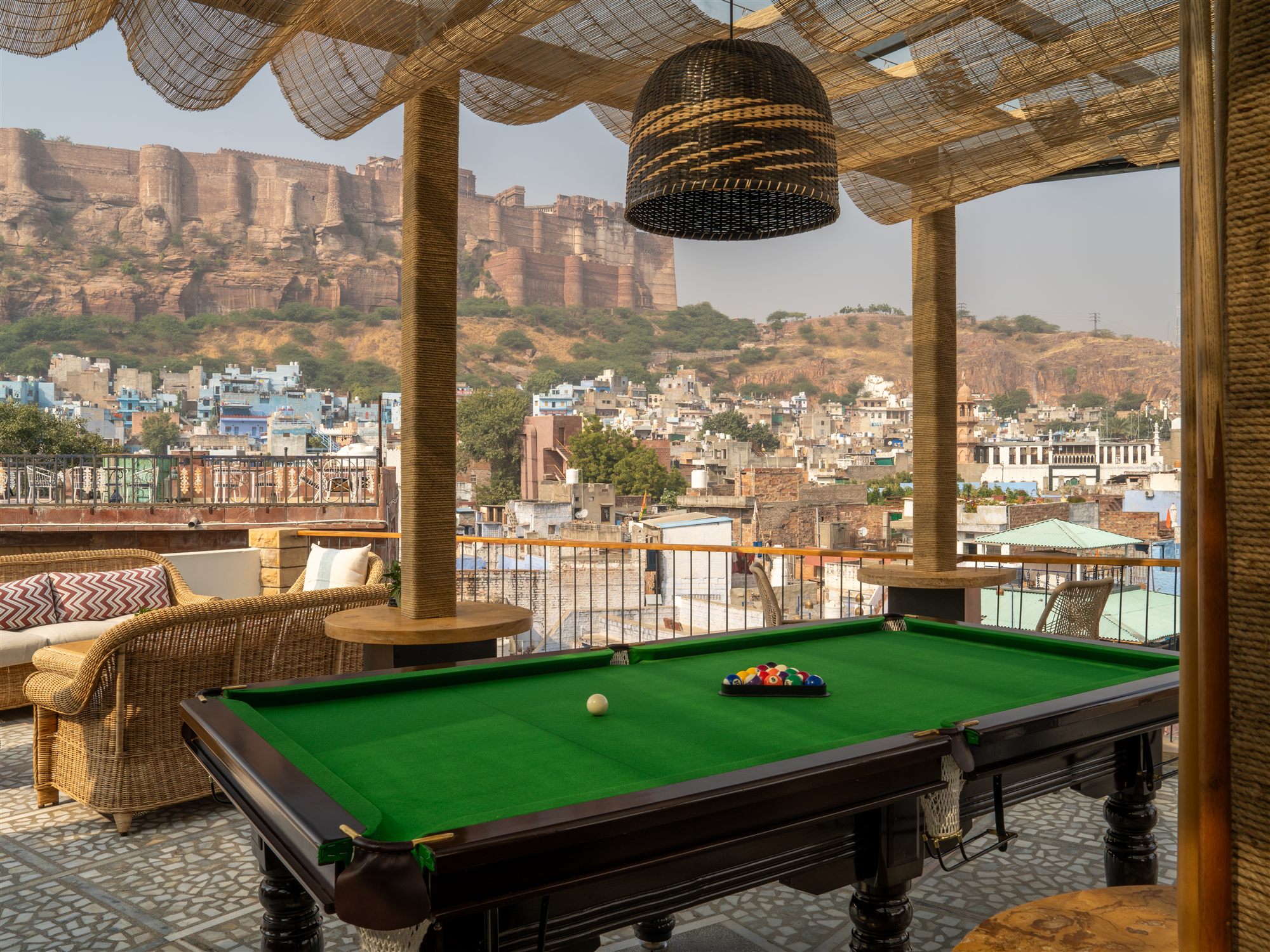 Billiards table on the terrace of The Stepwell Hotel Rooftop Restaurant with views over Jodhpur's blue city to Mehrangarh Fort