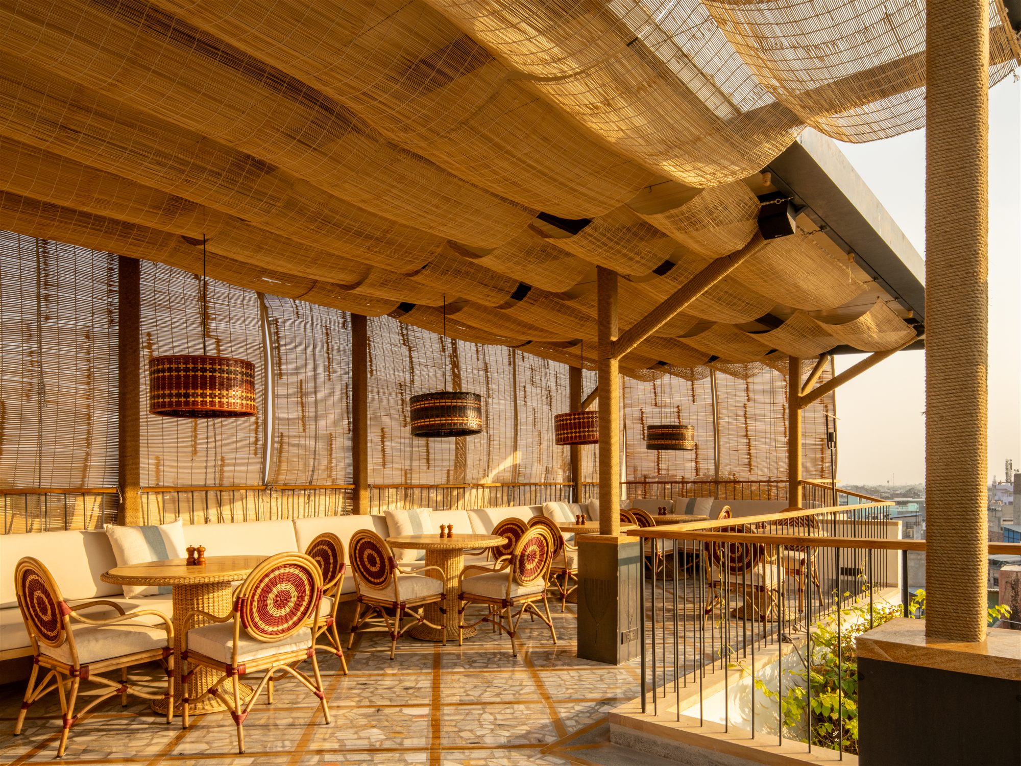The Stepwell Hotel Rooftop Restaurant in Jodhpur with canvas canopy, rattan chairs and patterned cushions