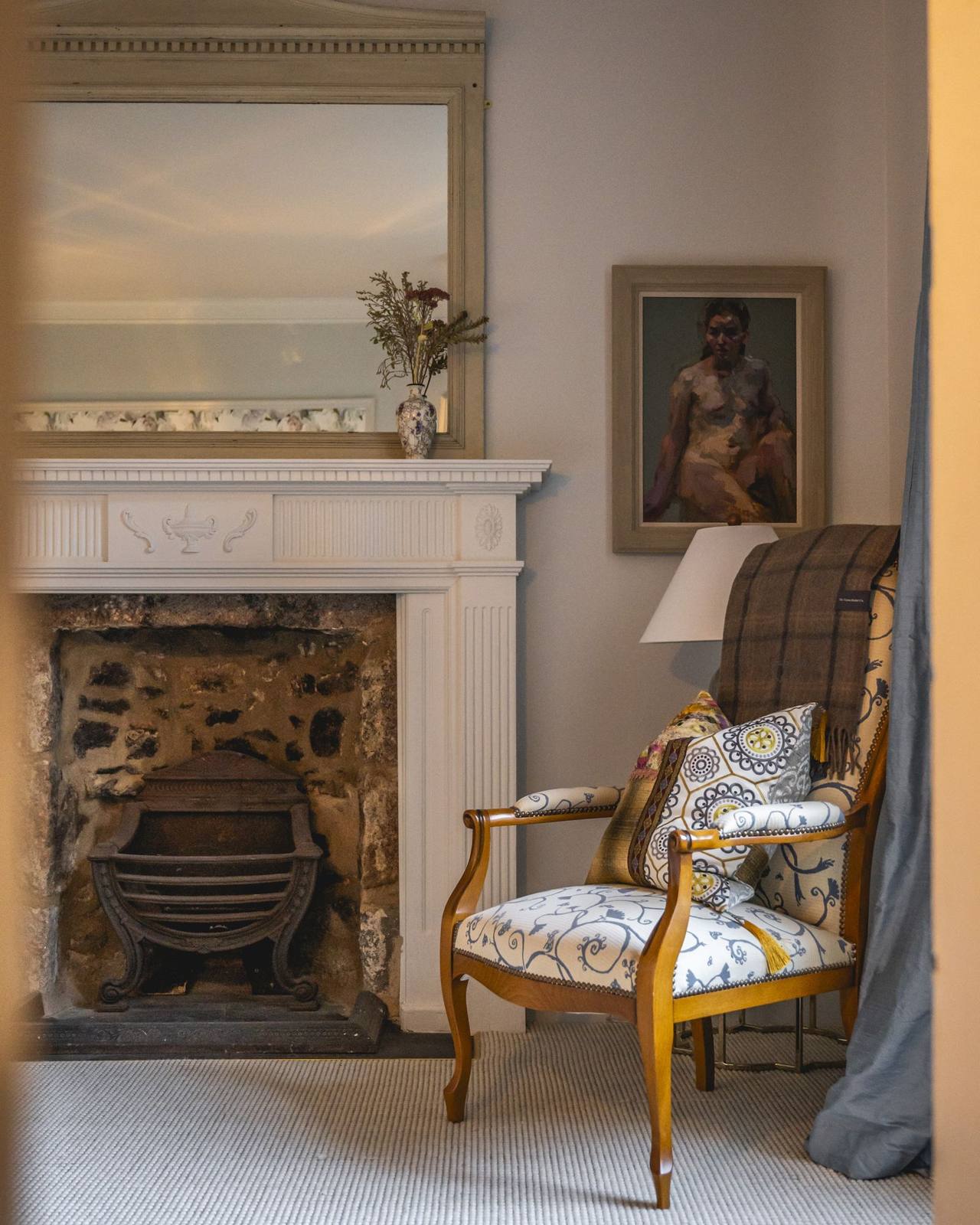 A fireplace and armchair in a sitting room at Manar House