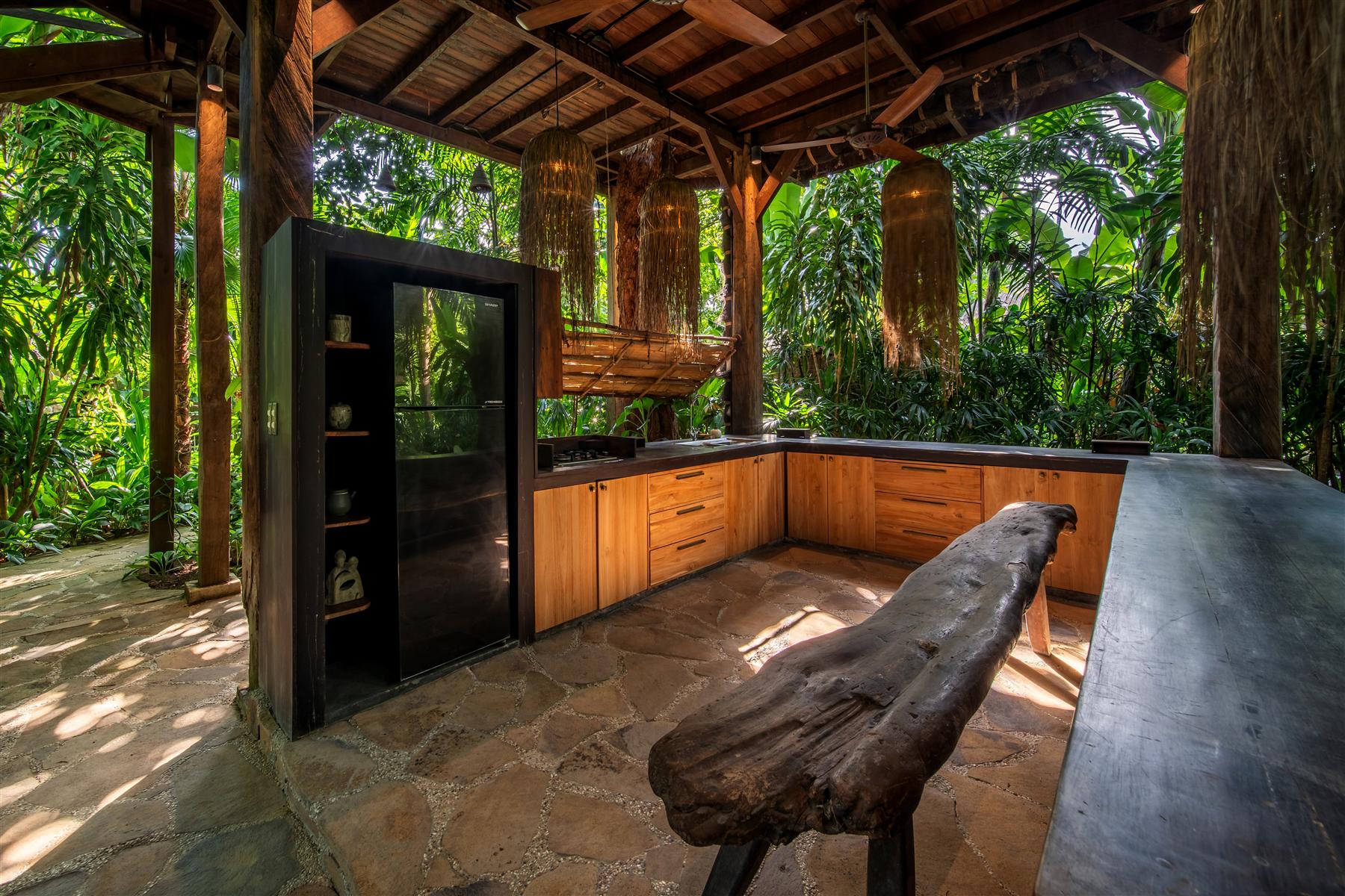 Open-air wooden kitchen at The Seed resort in Bali, surrounded by tropical jungle greenery