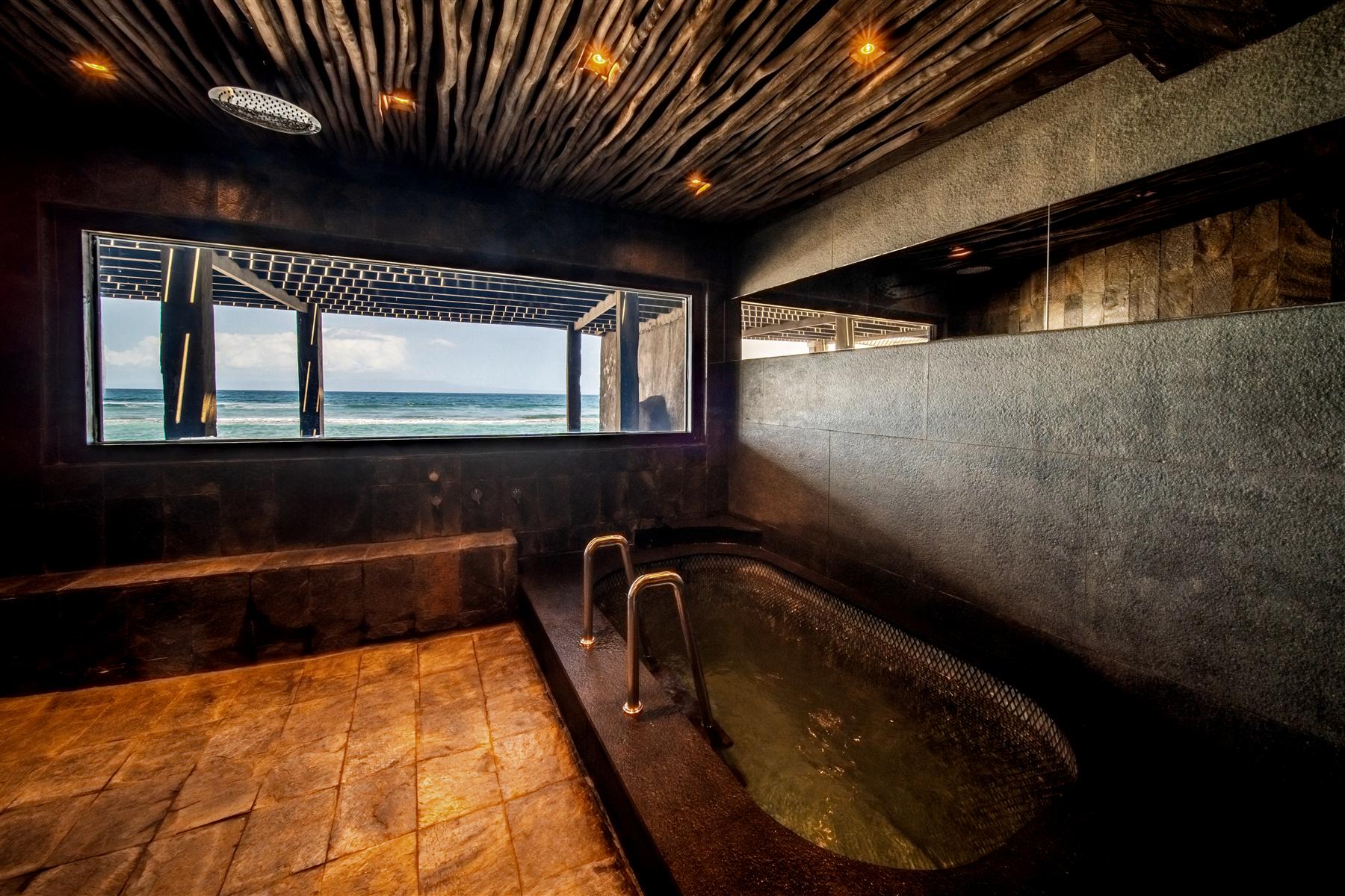 Cold plunge pool in the underground biohacking spa at The Seed, Candidasa, Bali, with ocean-view window
