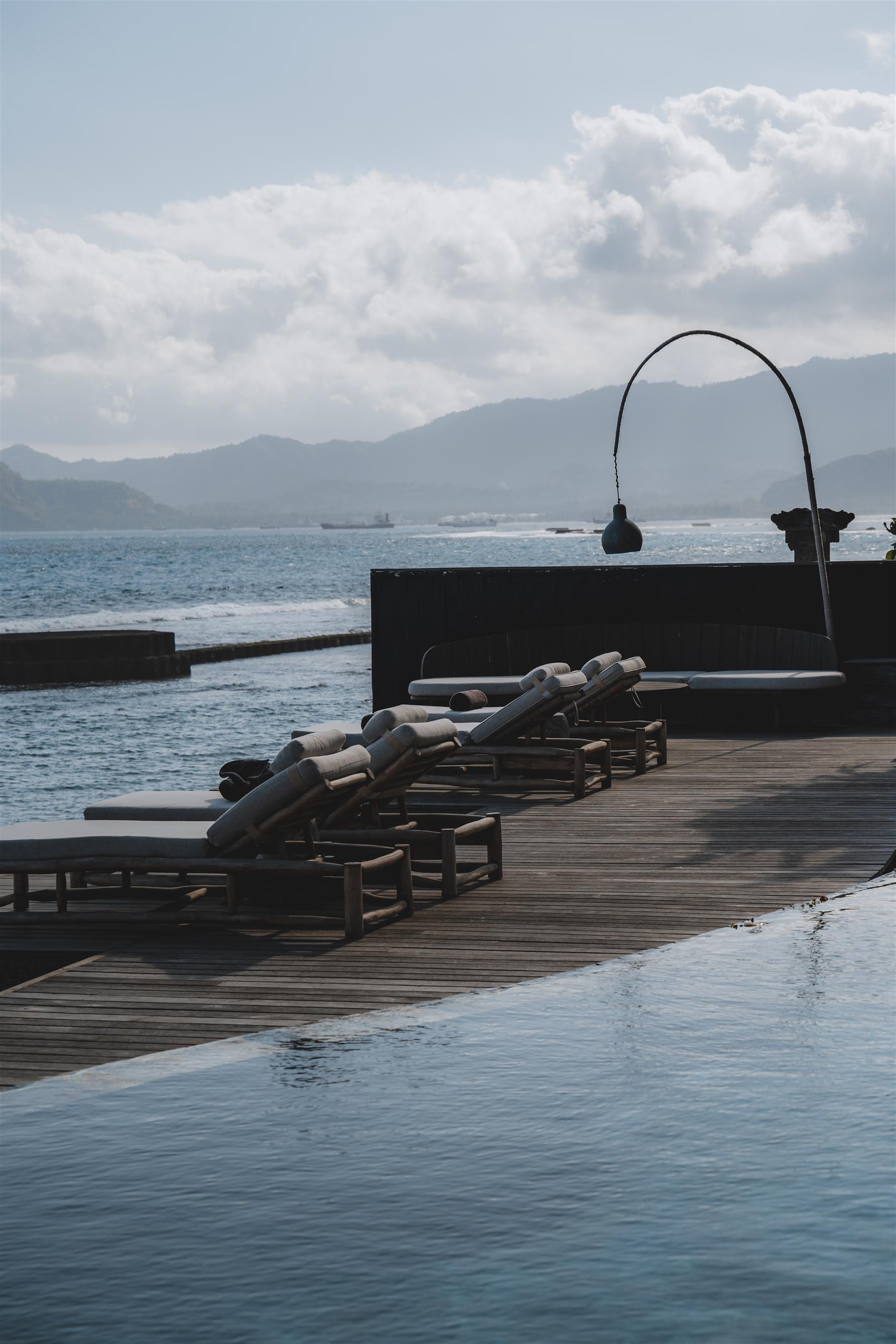 Ocean deck with loungers overlooking the sea at The Seed private resort in Candidasa, Bali